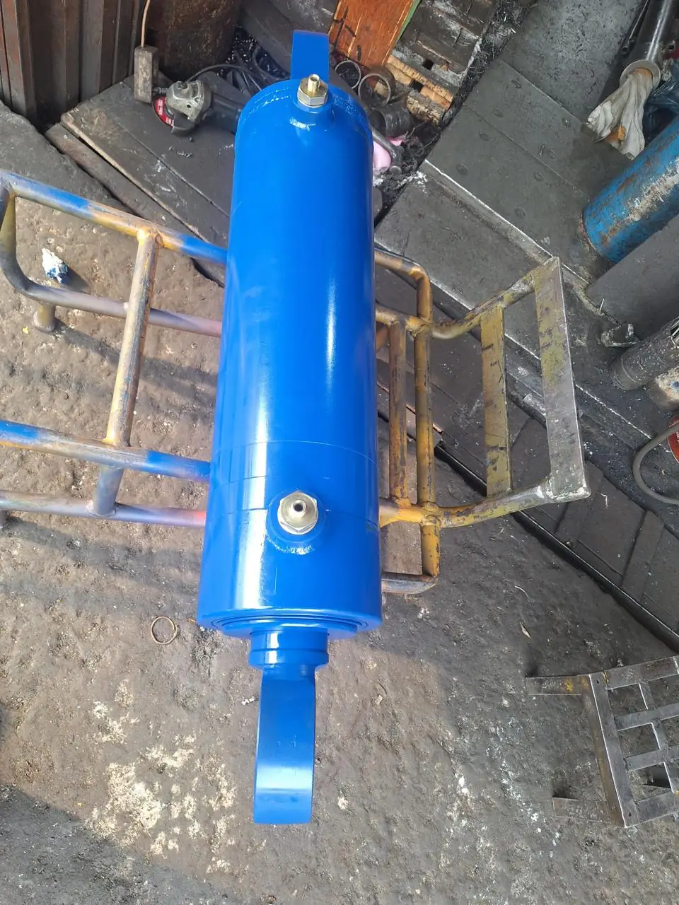 Custom blue hydraulic cylinder with grease and oil ports, top view