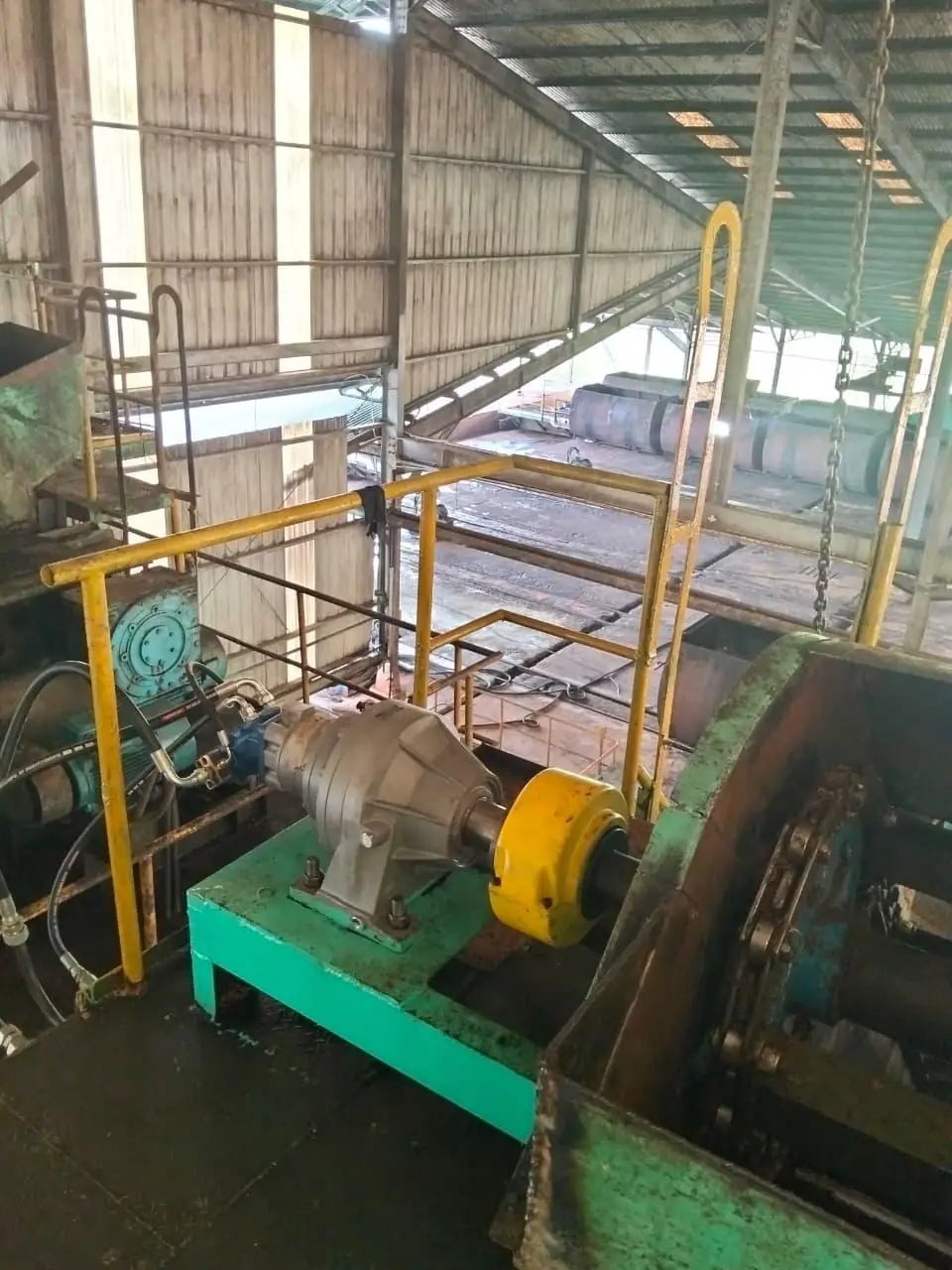 Hydraulic motor with gearbox driving a chain drive in a palm oil mill