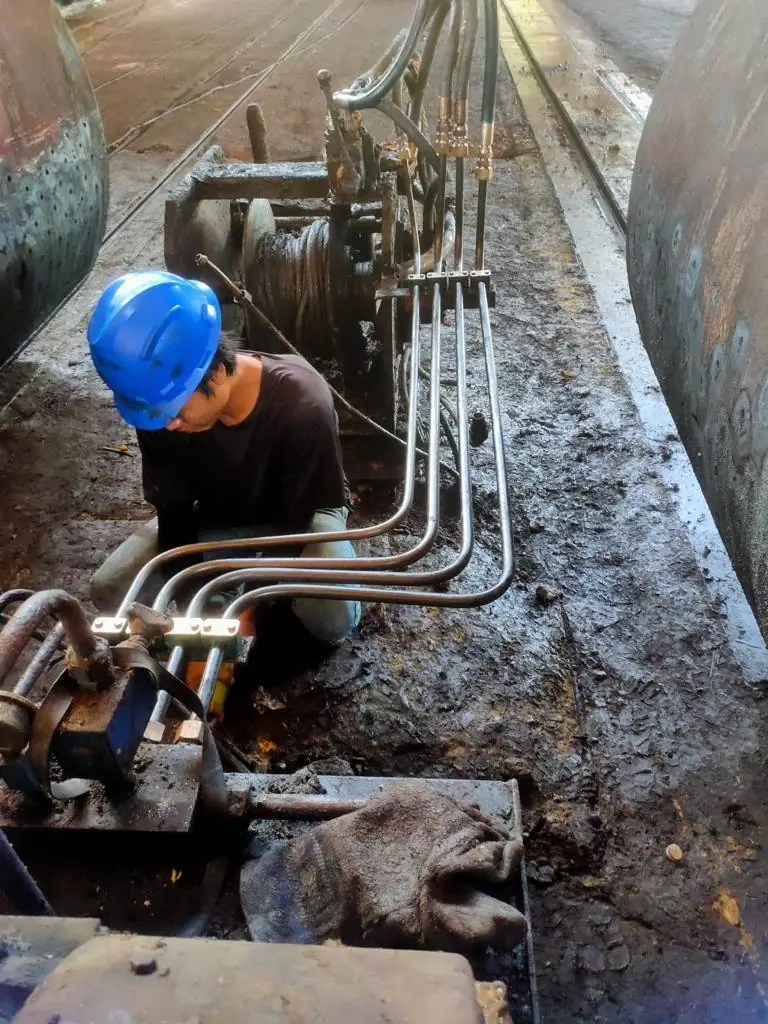 Technician installing hydraulic piping
