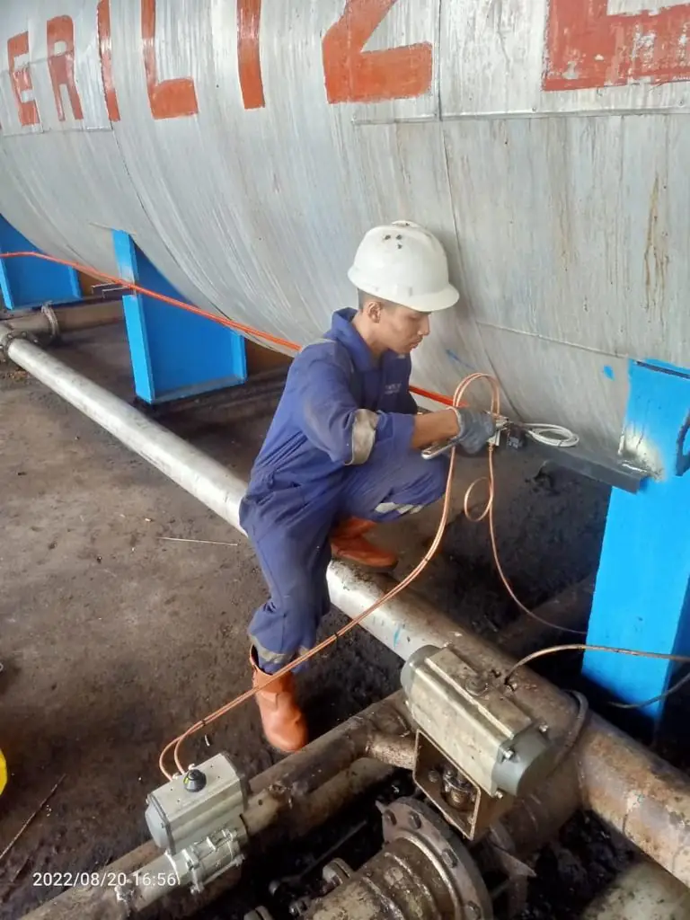 Technician servicing a pipe actuator