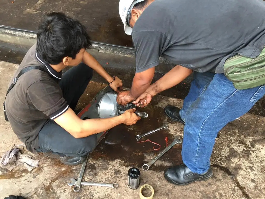 Technicians repairing a hydraulic unit on site